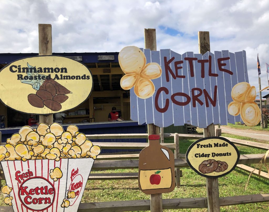 hand-painted signs advertise kettle corn, fresh made cider donuts, and cinnamon roasted almonds