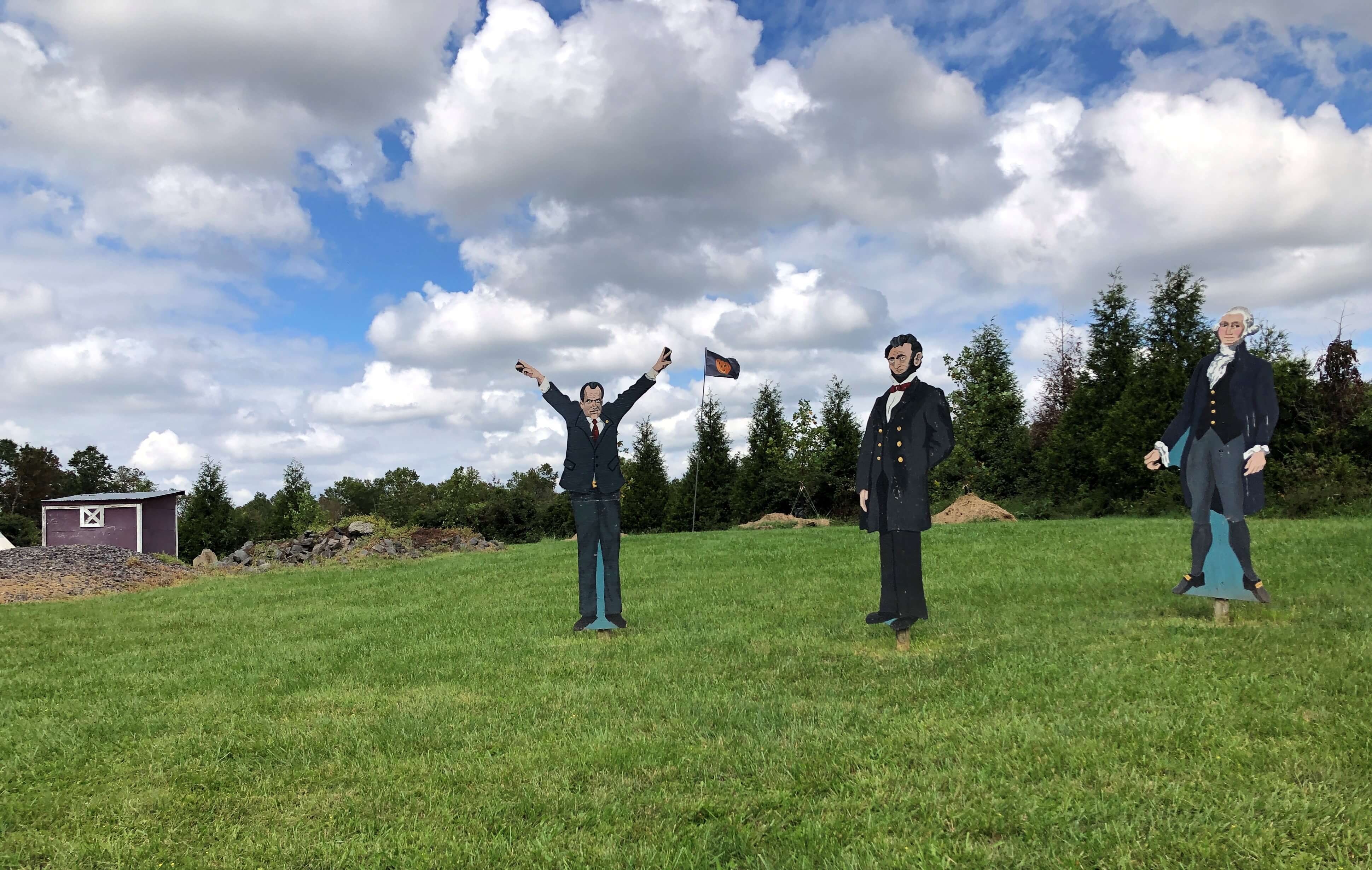 hand-painted cutouts of Presidents Richard Nixon, Abraham Lincoln, and George Washington line a grassy hillside