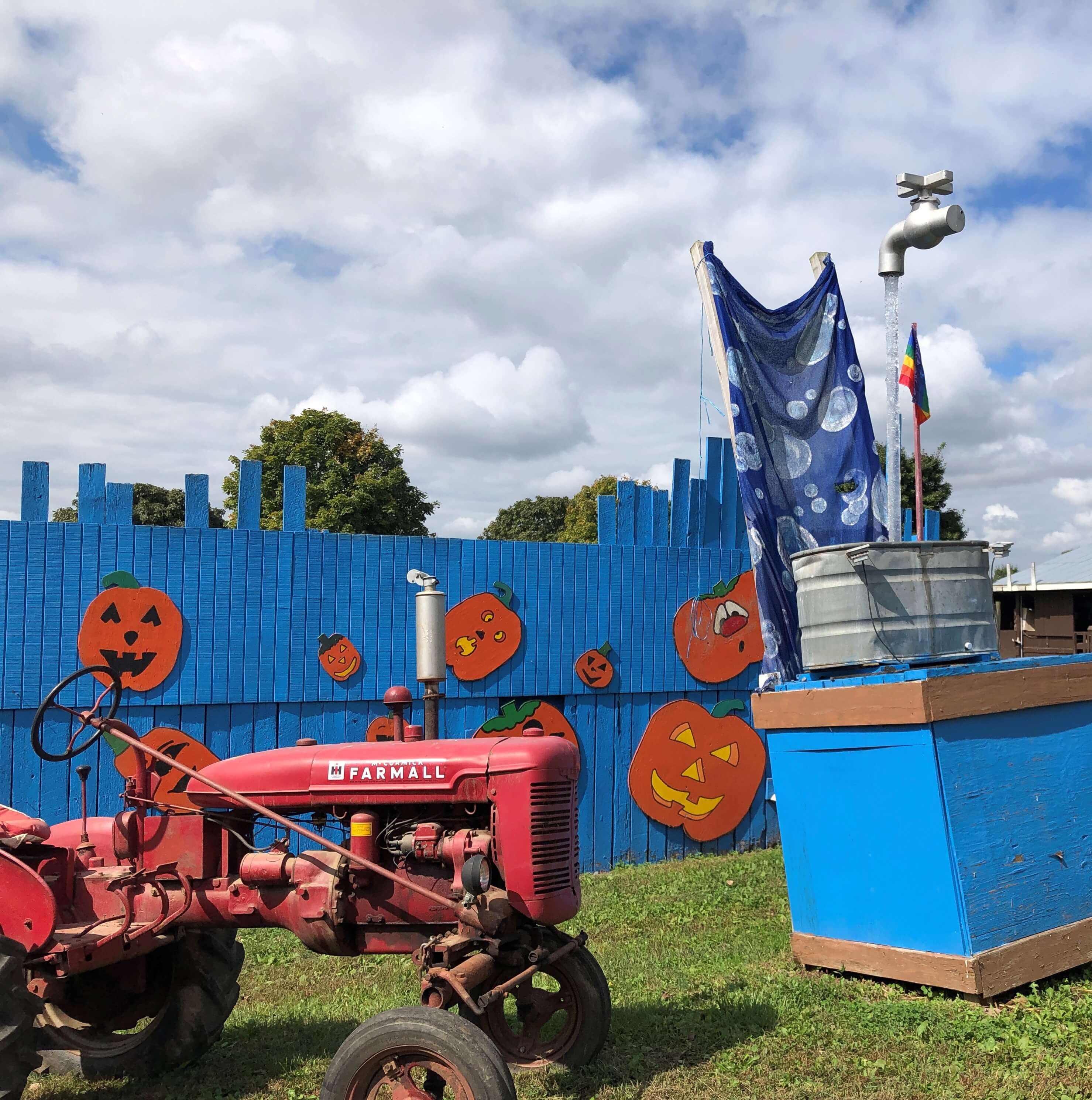 a tractor rests beside a spigot pouring water and seemingly hanging in thin air