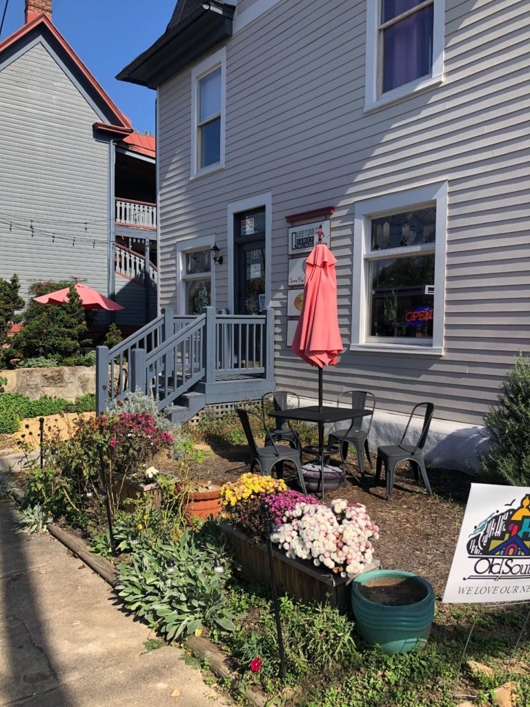 a garden flanks the entrance to a café