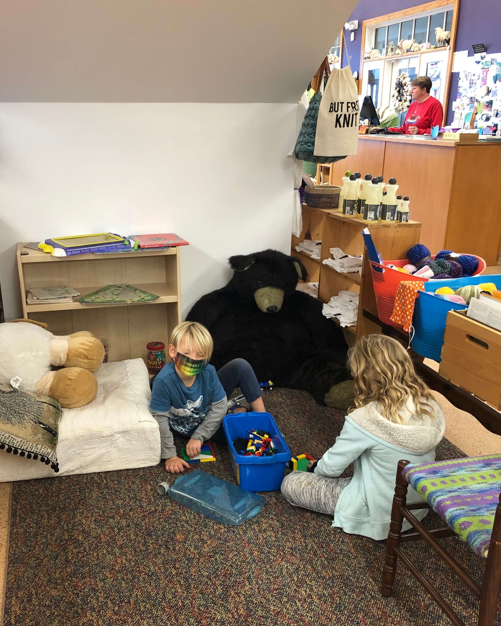 the children's play area of Knitting Addiction features Legos and stuffed animals