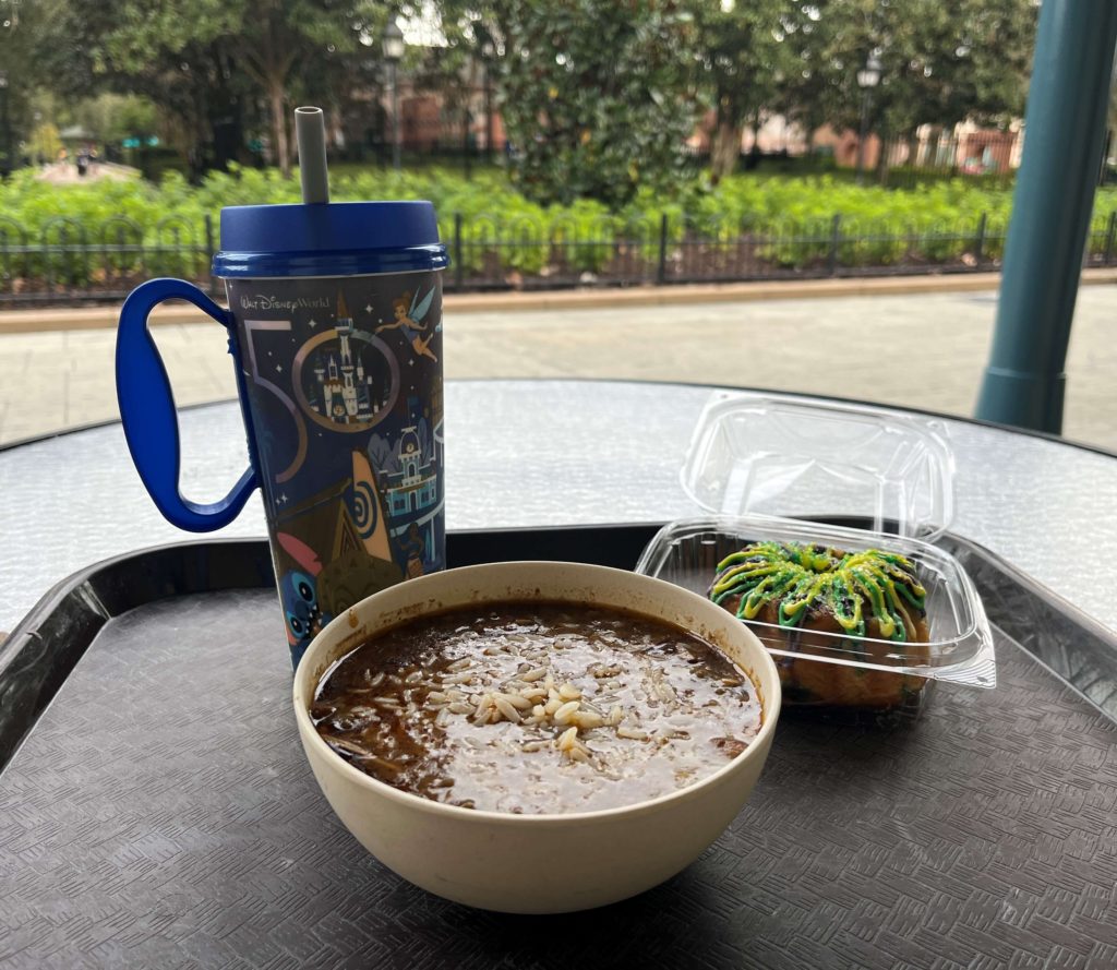 gumbo, king cake, and a reusable resort mug on a tray at Sassagoula Floatworks